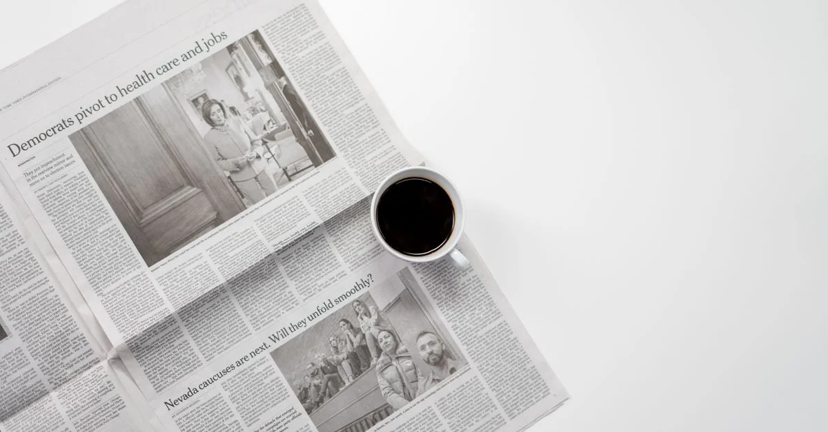 Une tasse de café frais reposant sur un journal, parfait pour une routine matinale.